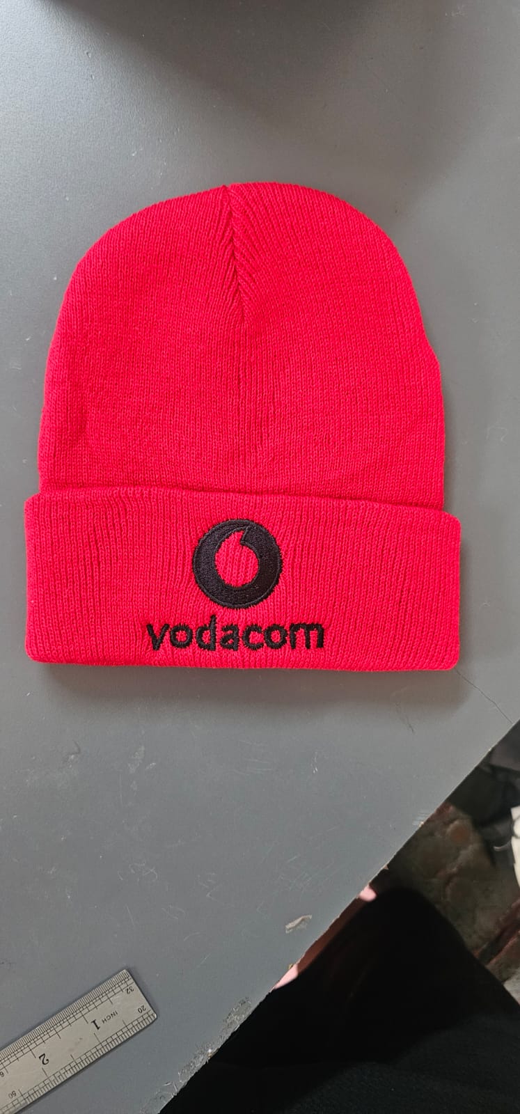 Red Vodacom branded cap produced as promotional apparel